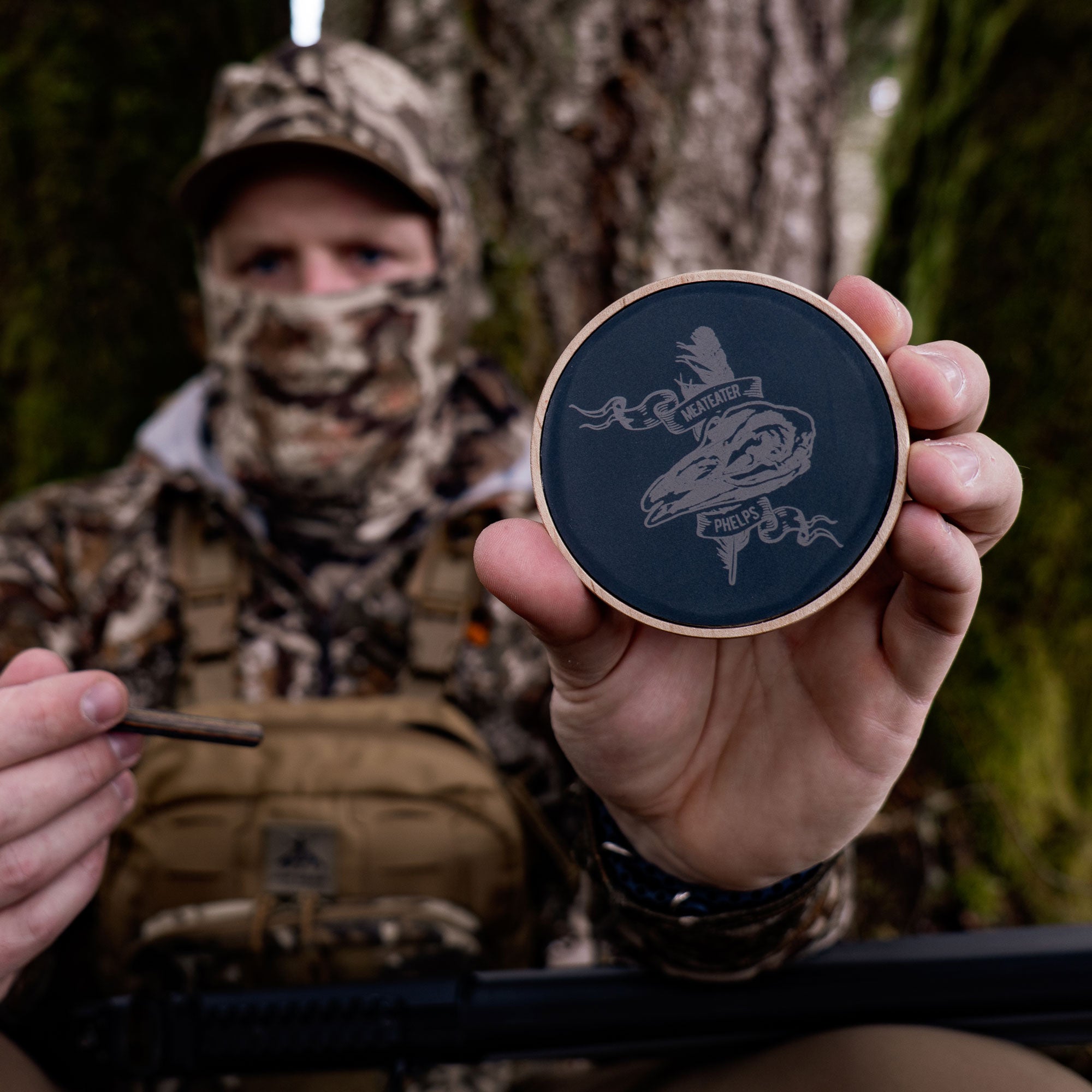 Dark blue turkey pot call with wood rim, engraved skull, and "Meateater Phelps" text.