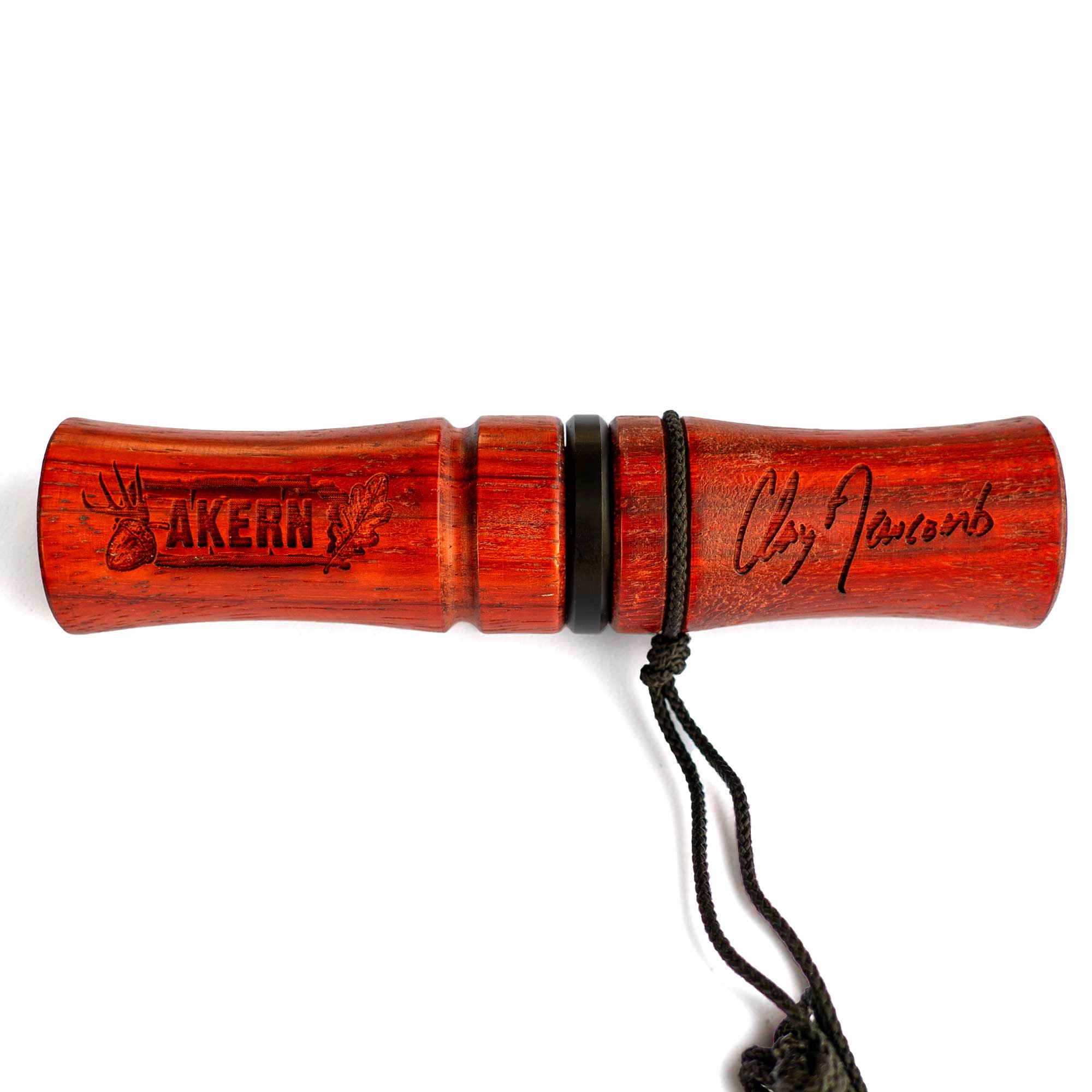 A padauk wood deer call with "Akern" text and Clay Newcomb signature on a white background