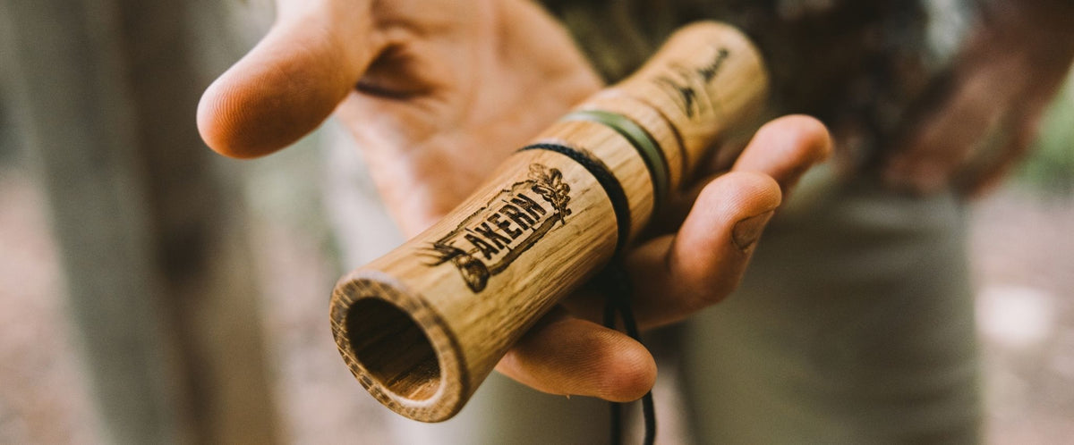 Man's hand holding a n Aker-n-grunt deer call with "AKERN" text on it.